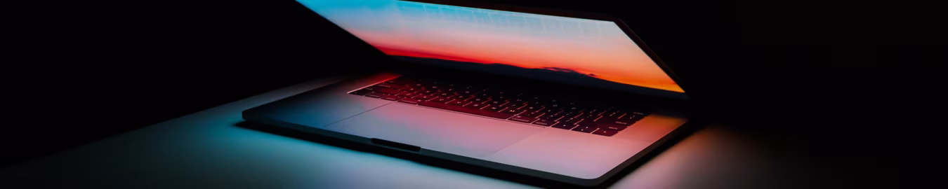 Laptop half open met kleurrijk schermlicht in donkere ruimte, sfeer van technologie, Communicatie