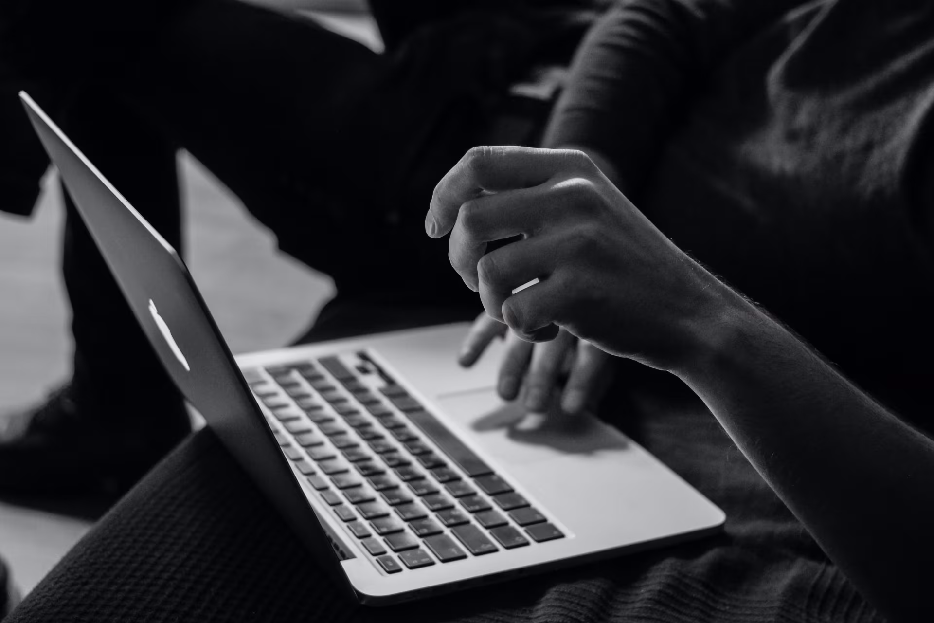 Close-up van handen op een Apple laptop die digitaal werken symboliseren bij diensten voor eventsontwikkeling en projectcoördinatie van Monique Krol